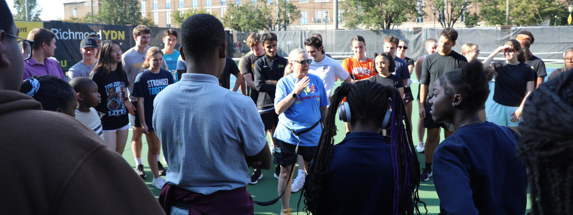 a circle group of youth outside with instructor in the middle